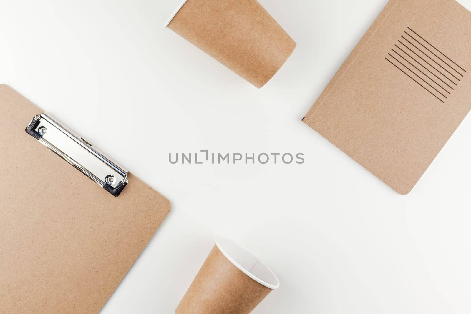 Creative top view flat lay of workspace desk styled recycled brown design office supplies and coffee cups with copy space white table background minimal eco style. Concept of environmental protection