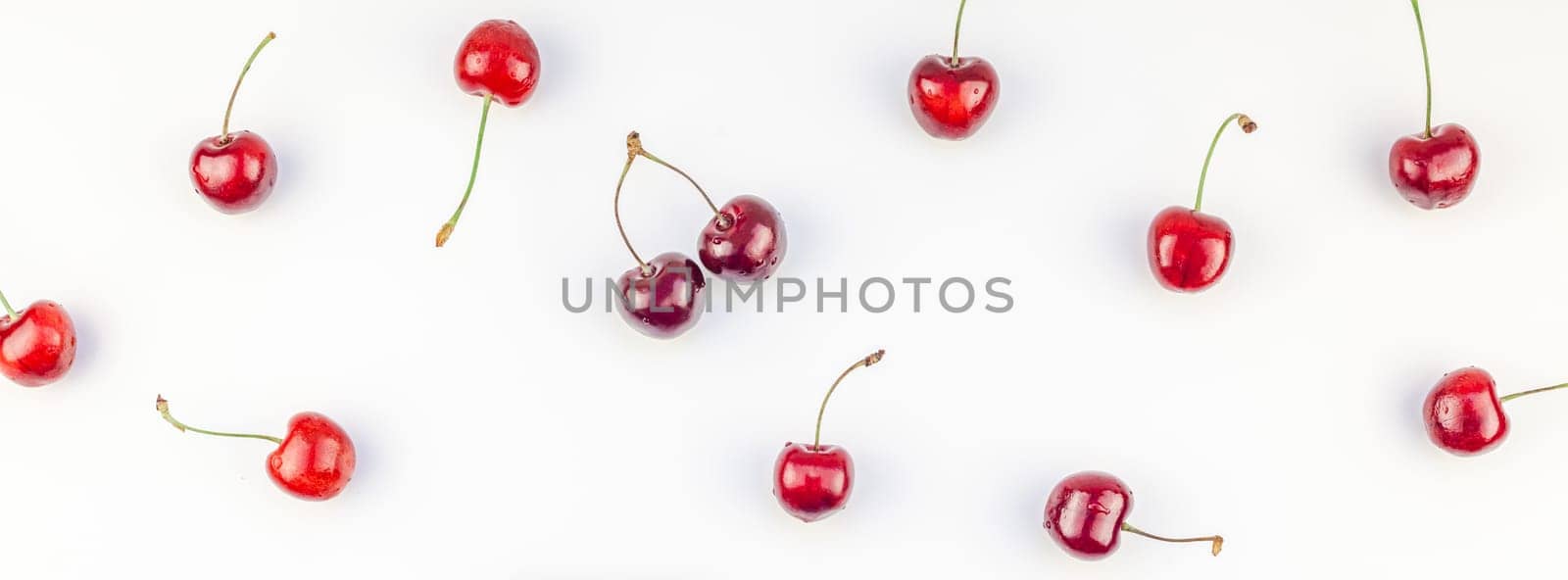 Long wide banner of fresh ripe cherry pattern layout with copy space isolated on white background in minimal style. Concept of summer fun and healthy eating. Template for your text or food design