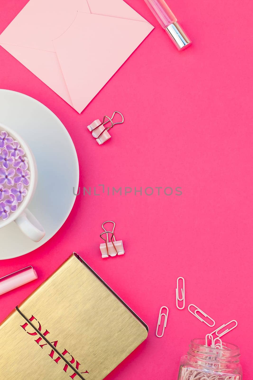 Creative top view flat lay of workspace desk styled design office supplies and cup of tea with copy space on a bright pink color paper background minimal style. Template for feminine blog social media
