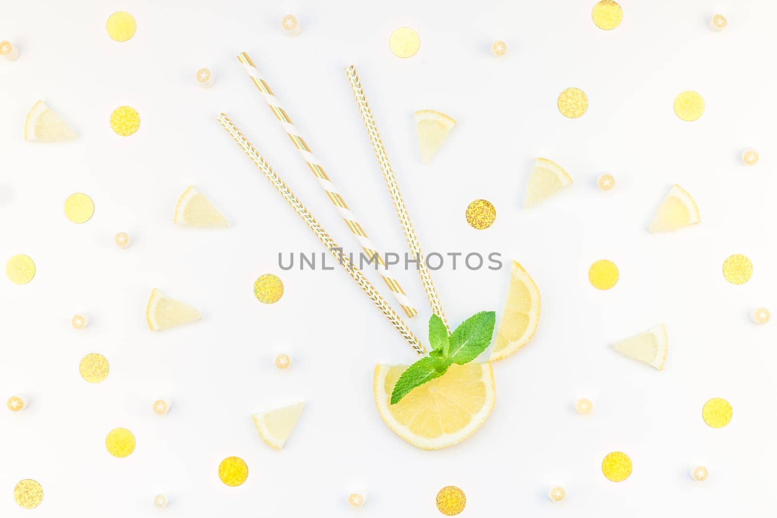 Creative flatlay overhead top view citrus lemon slices and mint herbs leaves white table background with copyspace. Hot summer refreshment lemonade concept. Beverage ingredients arranged with straws