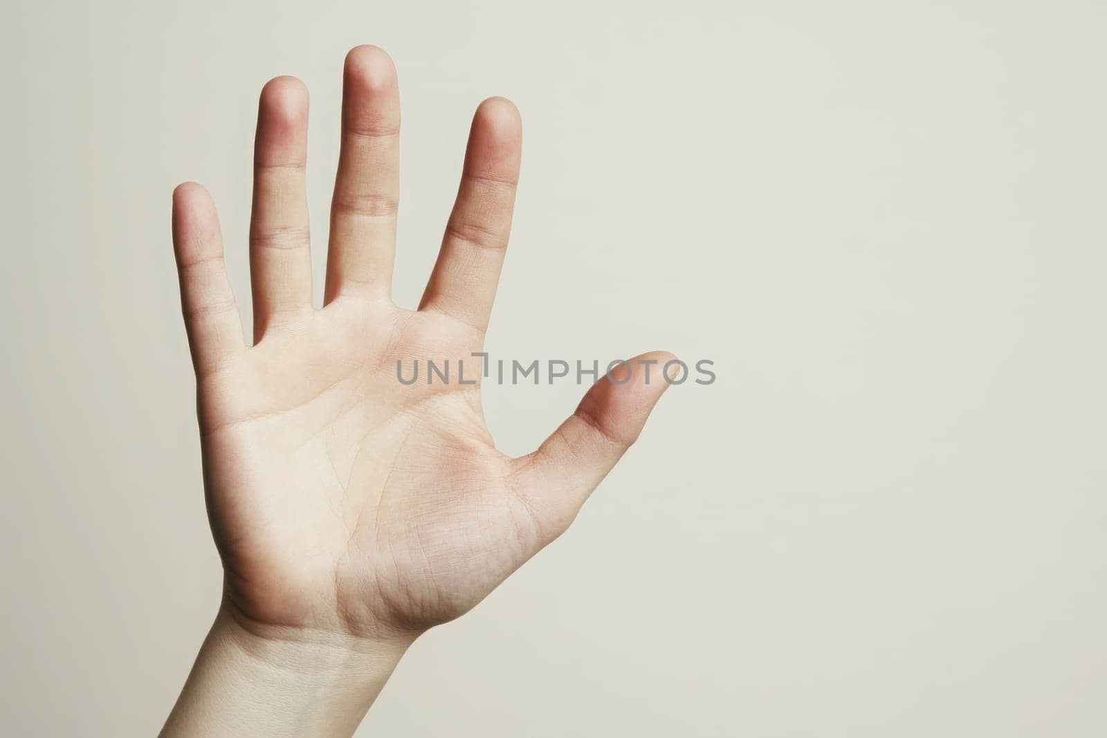 A hand with fingers spread wide is extended outward, showcasing an open palm against a simple, clean background. The image conveys a sense of openness and invitation, captured in soft lighting.