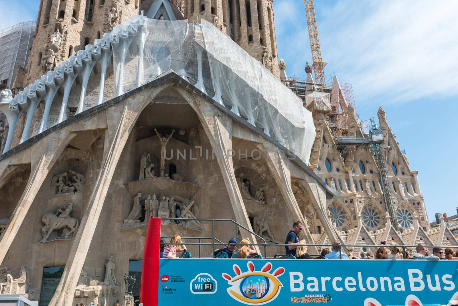 SPAIN, BARCELONA - SEPTEMBER 13: People sitting on a double decker tourist coach in front of The Sagrada Familia Cathedral in Barcelona on September 13, 2015