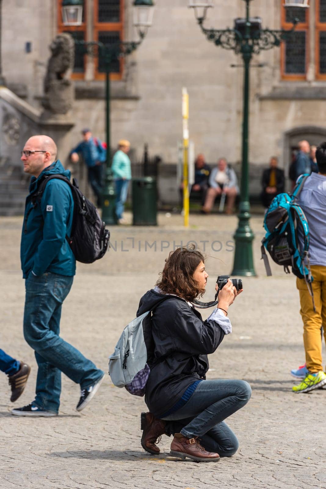 BELGIUM, BRUGES - MAY 22: Woman is taking pictures on the street of Bruges on May 22, 2015