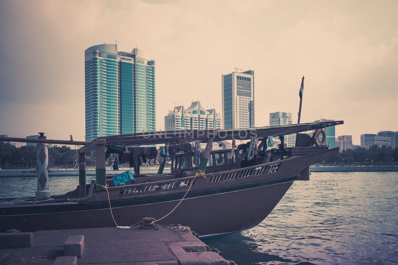 Abu Dhabi buildings skyline with old fishing boats on the front. Filtered shot