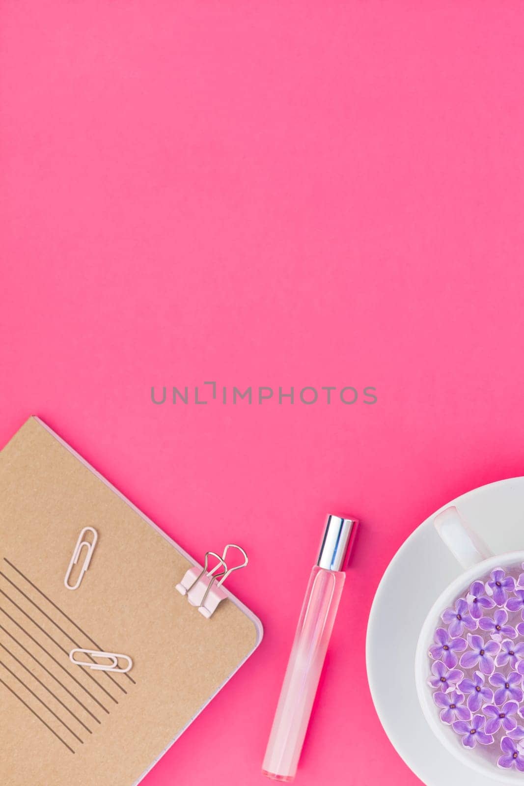 Creative top view flat lay of workspace desk styled design office supplies and cup of tea with copy space on a bright pink color paper background minimal style. Template for feminine blog social media