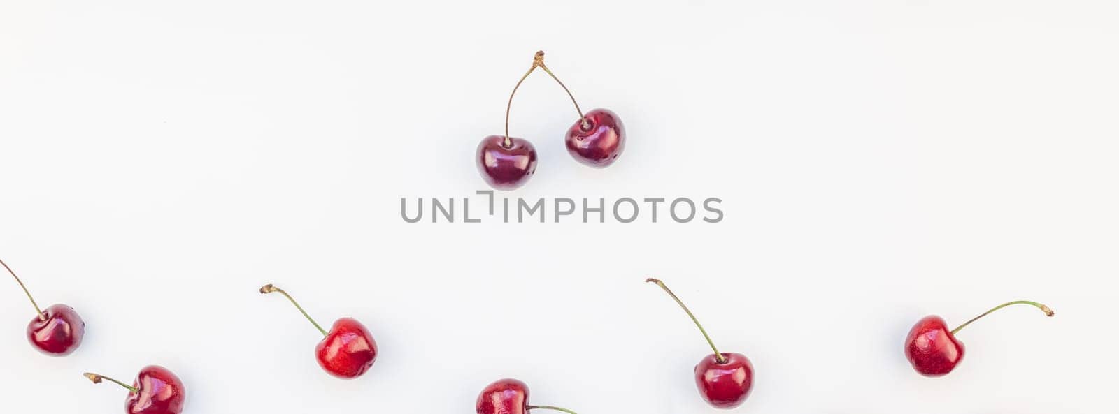 Long wide banner of fresh ripe cherry pattern layout with copy space isolated on white background in minimal style. Concept of summer fun and healthy eating. Template for your text or food design