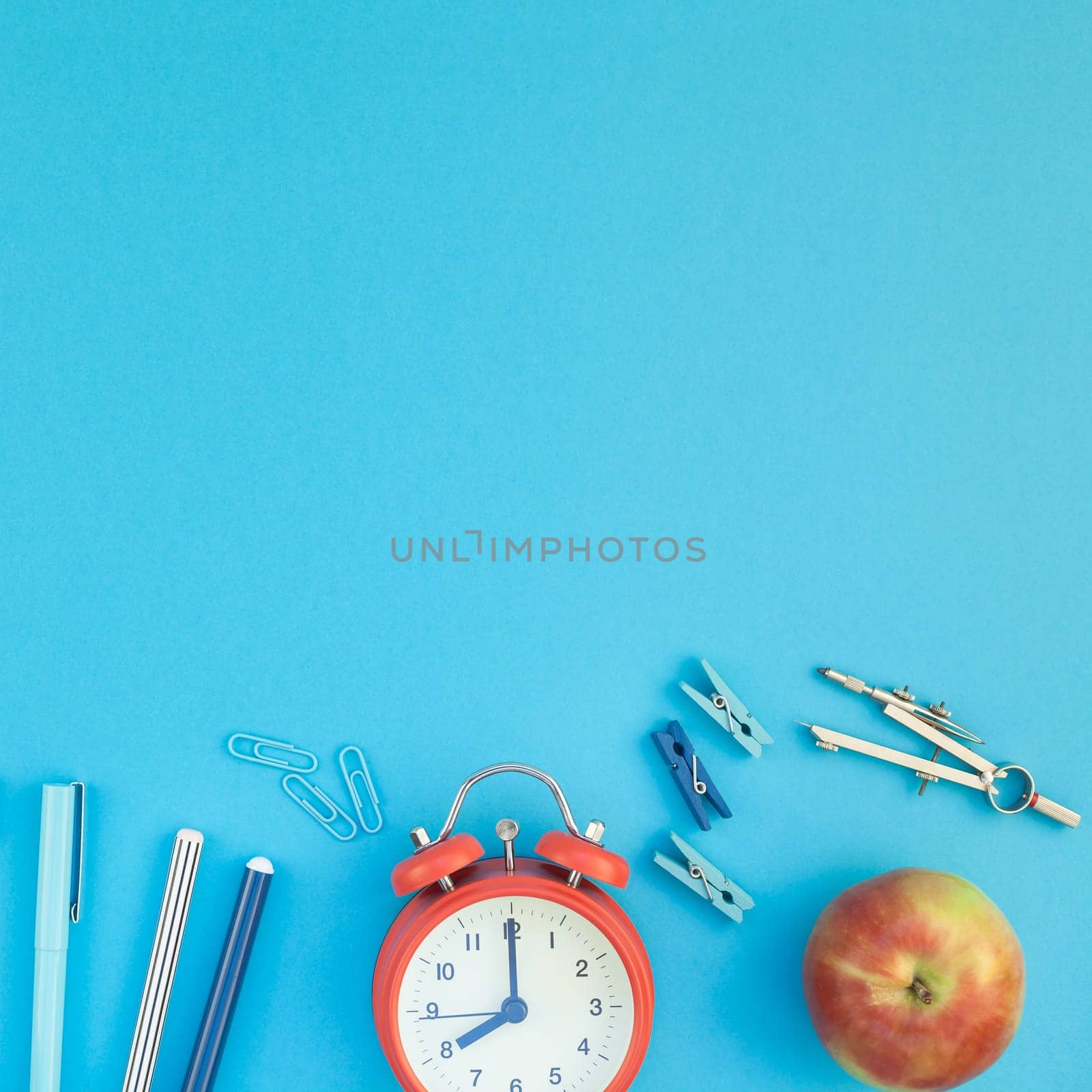Square Creative flat lay top view back to school concept with alarm clock color school and office supplies on bright turquoise paper table frame background with copy space, template for text or design