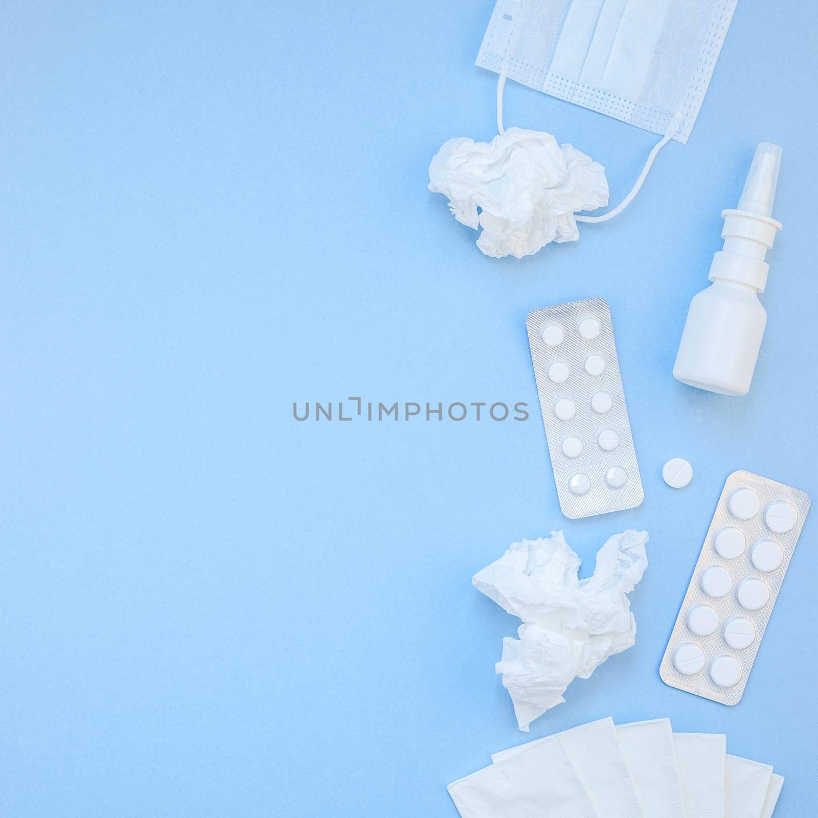 Creative flat lay concept of seasonal spring allergy with napkins, pills, face mask and drops in a bottle with copy space square background minimal style, template for text