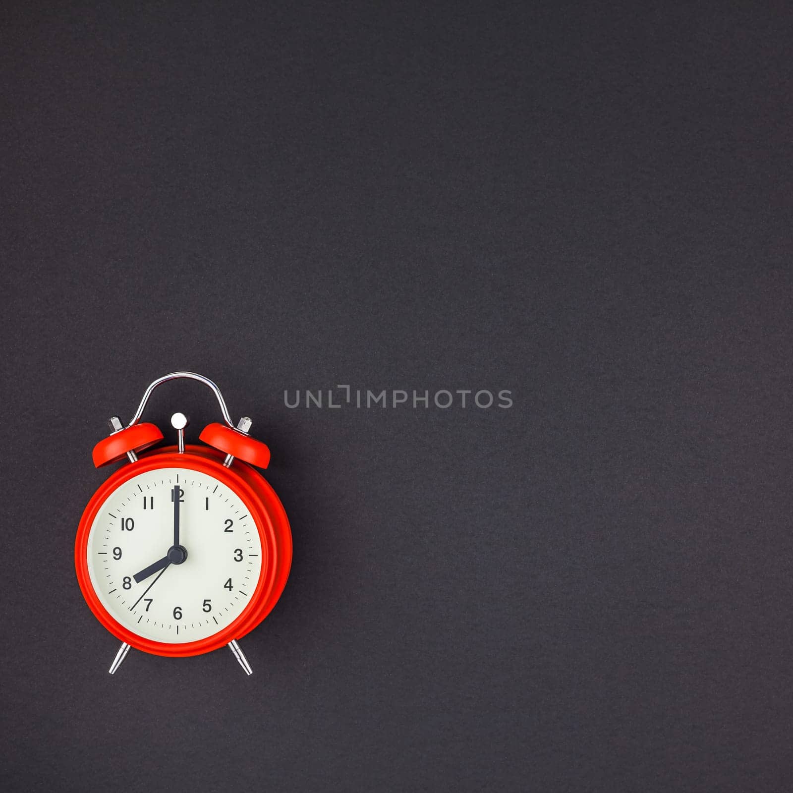 Concept image of a red vintage alarm clock with eight o clock on square dark black color paper background with copy space in minimal style, template for text