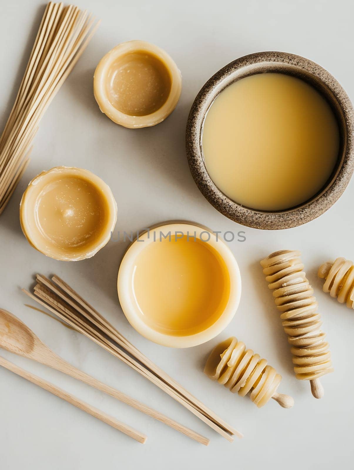An assortment of natural beeswax products, including candles and honey, arranged artistically on a table.