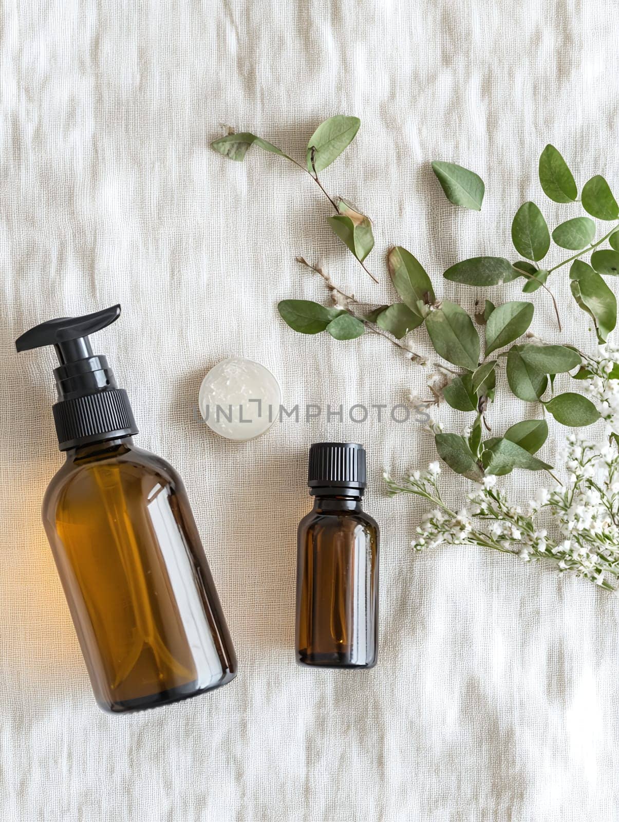 Herbal beauty products in glass bottles set against a linen background, complemented by green leaves.