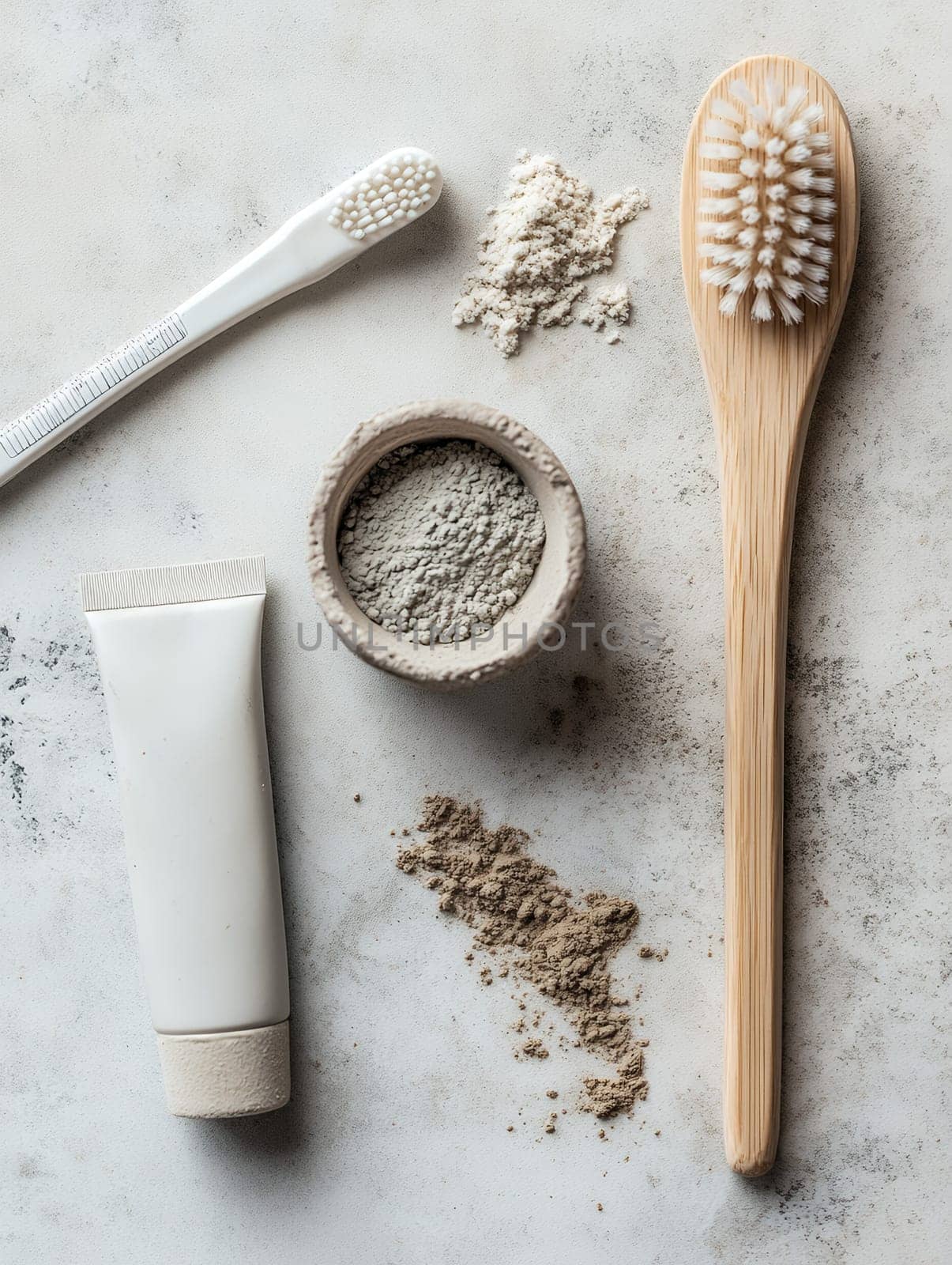 An eco-friendly dental care set with bamboo toothbrush, toothpaste, and natural powders on a light surface.