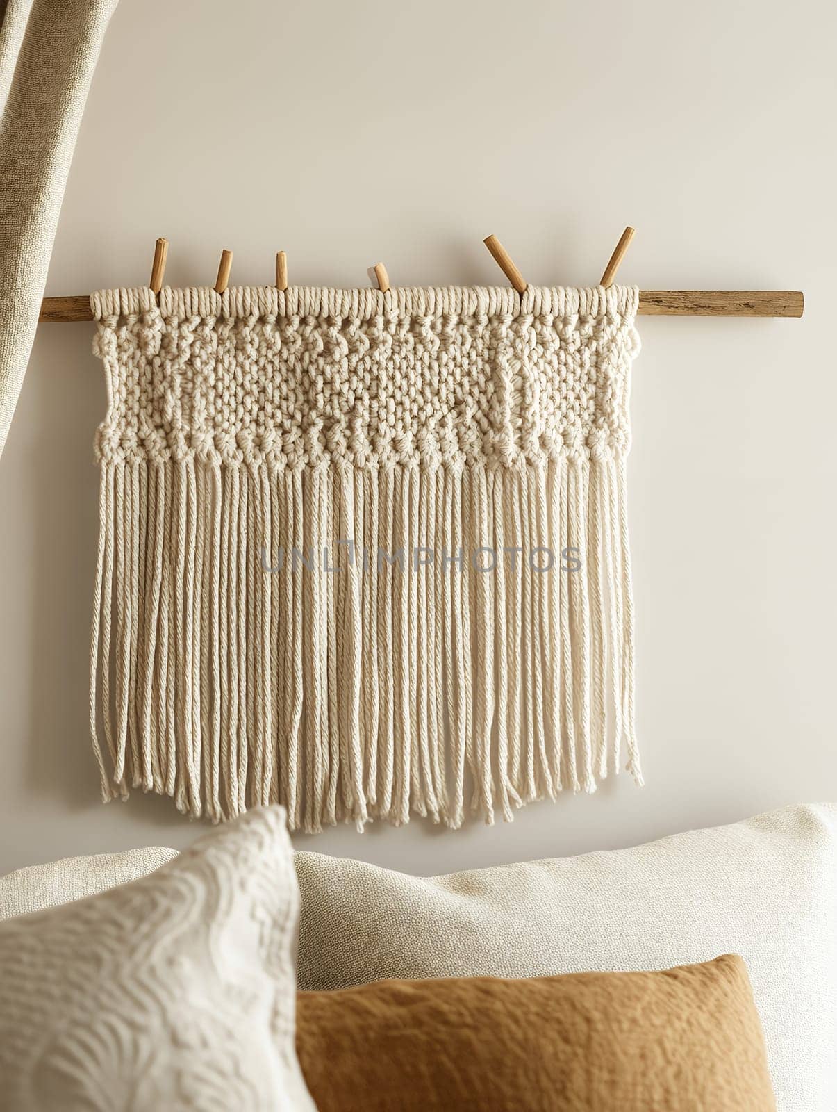 A simple macrame wall hanging decorates a neutral-toned room, adding texture and elegance to the space.