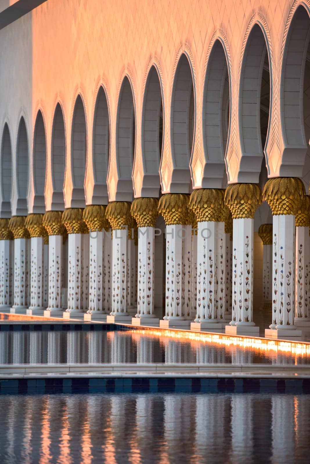 Beautiful gallery of famous Sheikh Zayed White Mosque in Abu Dhabi, UAE. Reflections at sunset