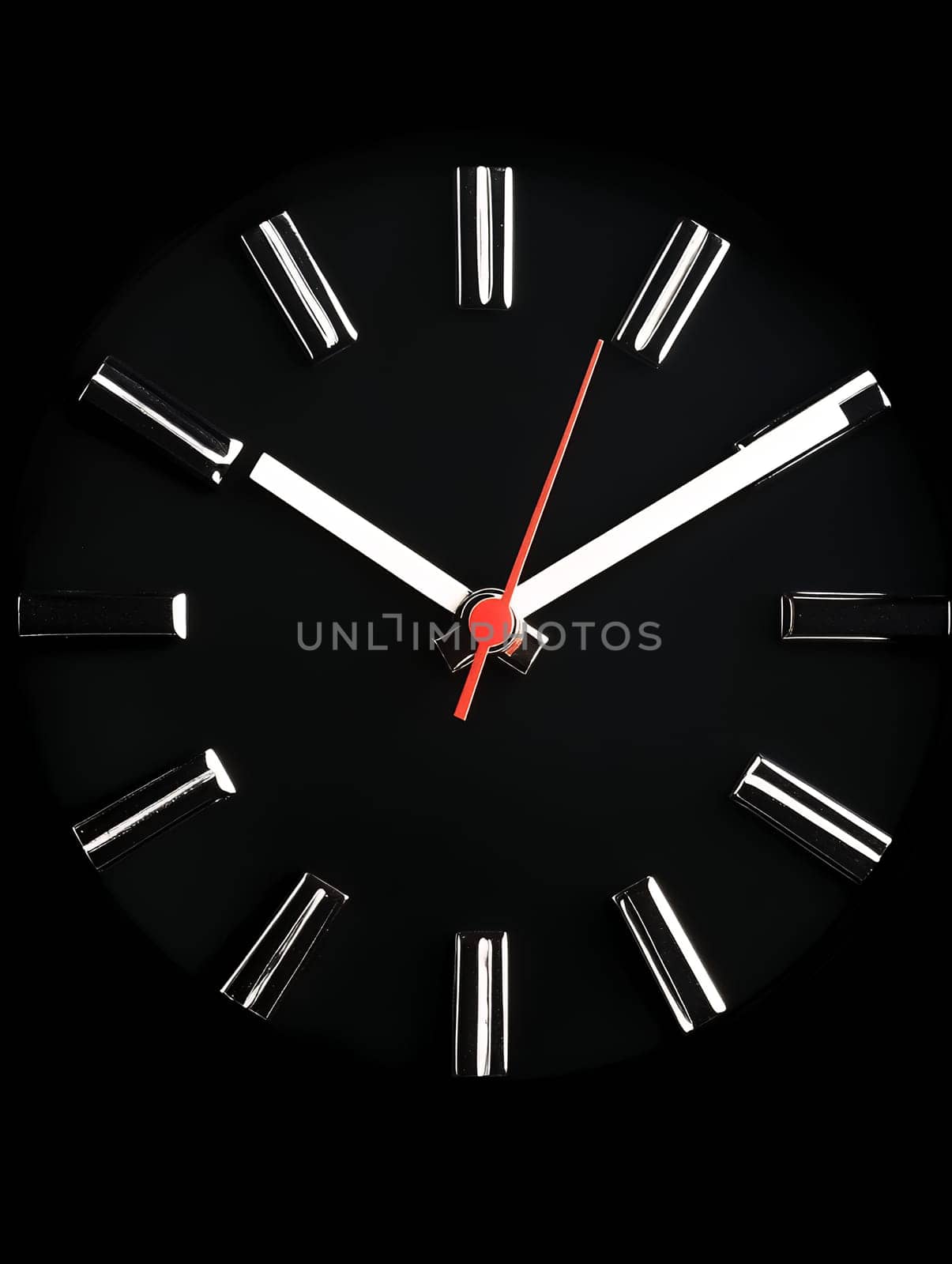 Minimalist black wall clock with white markings and red second hand against dark background. Modern timepiece design showing almost midnight.