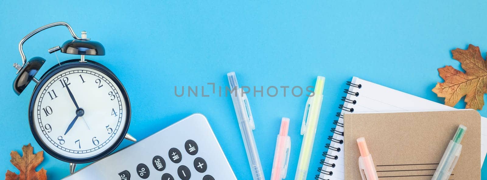 Creative flat lay top view back to school concept with color school and office supplies on bright turquoise paper table frame background with copy space, template for text or design. Long wide banner