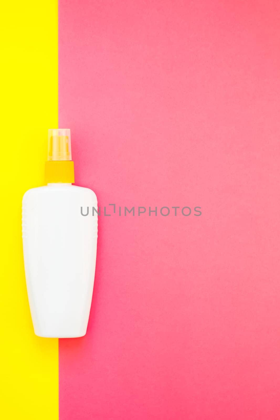Sunscreen blank bottle mockup on bright yellow and pink duotone paper background. Summer vacations creative flat lay concept template for text