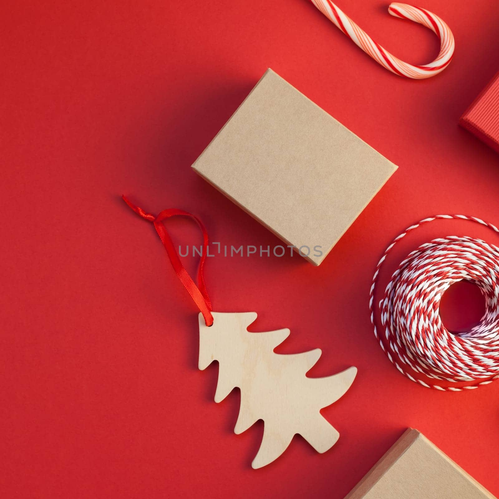 New Year Christmas presents wrapped with ribbon flat lay top view Xmas holiday 2019 celebration handmade gift boxes red paper background copyspace. Square Template mockup for greeting card text design