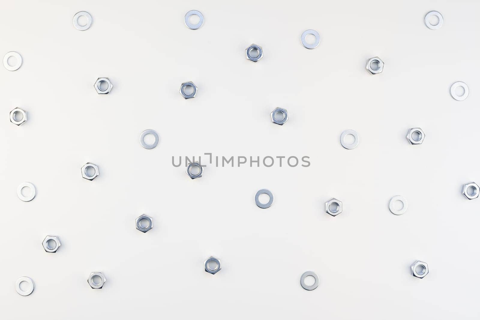 Creative Flat lay of metal nuts on white background. Repair or improvement top view concept pattern.