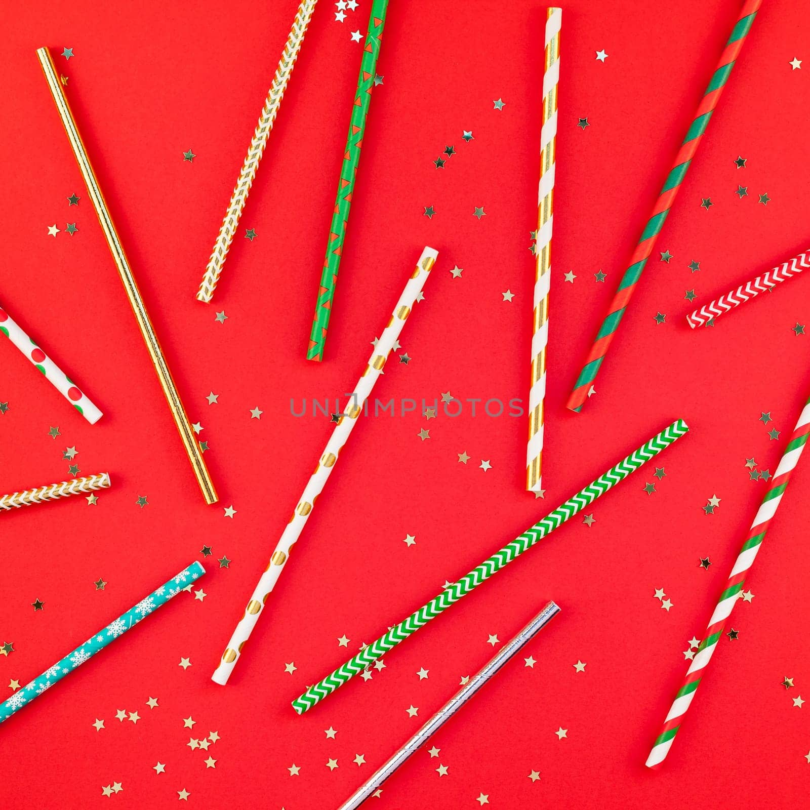 New Year or Christmas pattern flat lay top view Xmas 2019 holiday celebration drinking cocktail party straws red paper golden sparkles background. Square Template for greeting card your text design