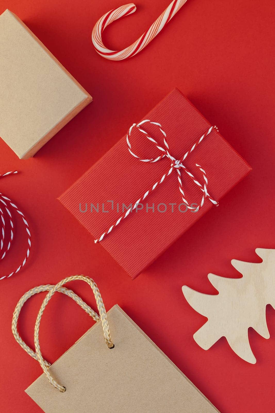 New Year or Christmas presents wrapped with ribbon flat lay top view Xmas 2019 holiday celebration handmade gift boxes on red paper background copyspace. Template mockup greeting card your text design