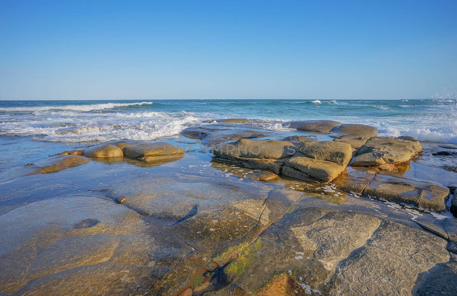 Surf waves breaking over the rocky headland at Point Cartwright at Kawana on Queensland's Sunshine Coast