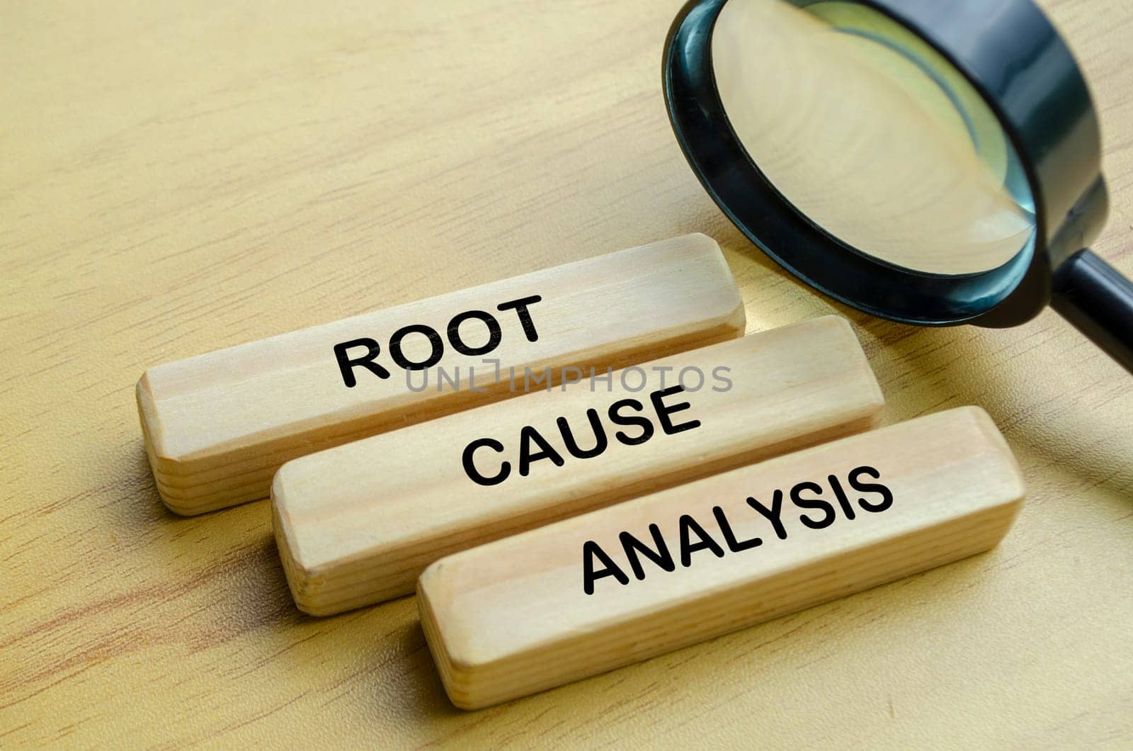Root Cause Analysis text on wooden blocks with magnifying glass background.