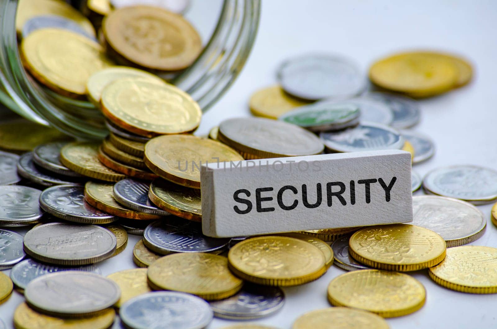 Security text on white wooden block with coins and jar background. Life security concept.
