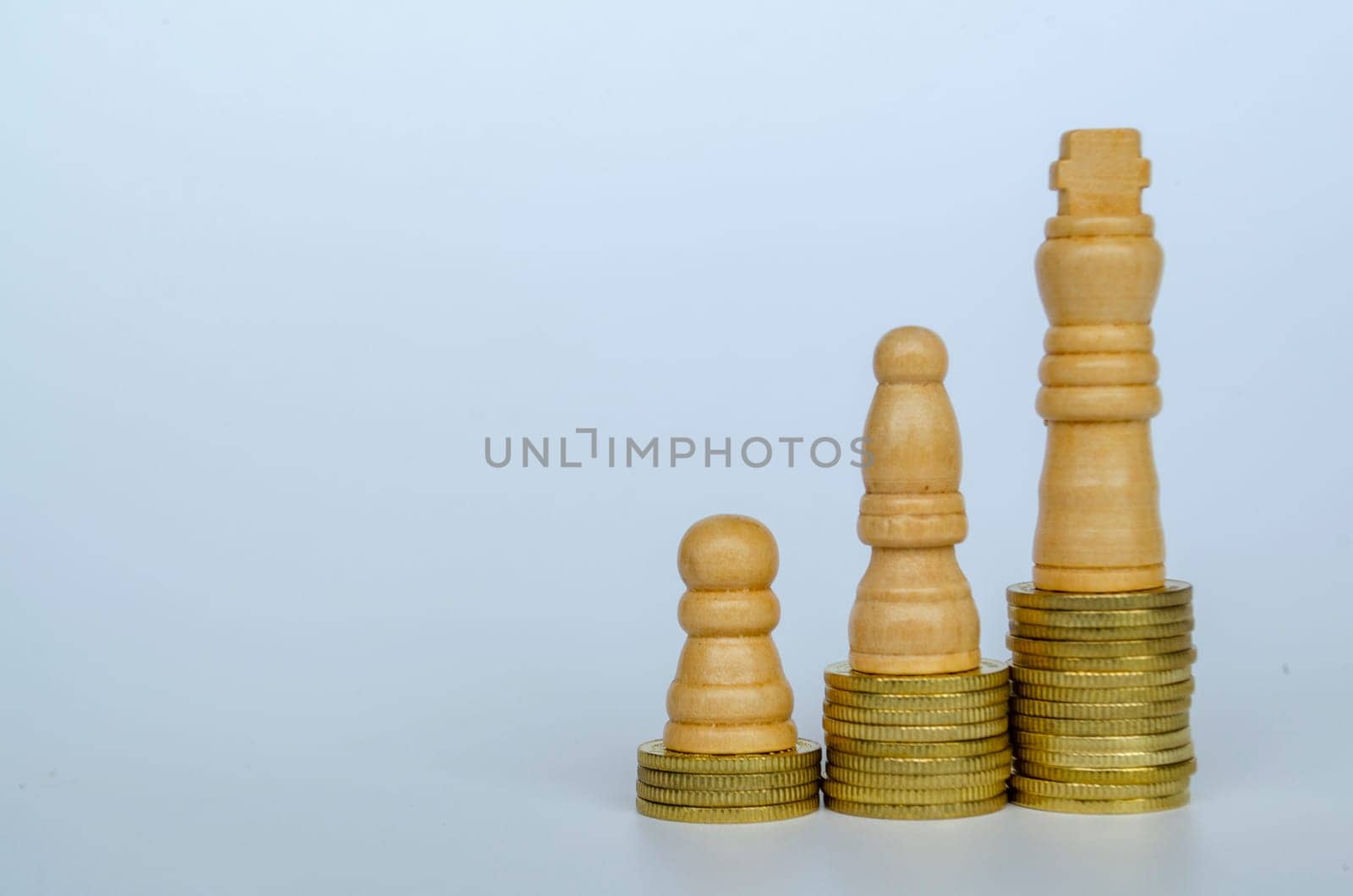Chess pawns on top of golden stacking coins representing wealth and power with customizable space for text.