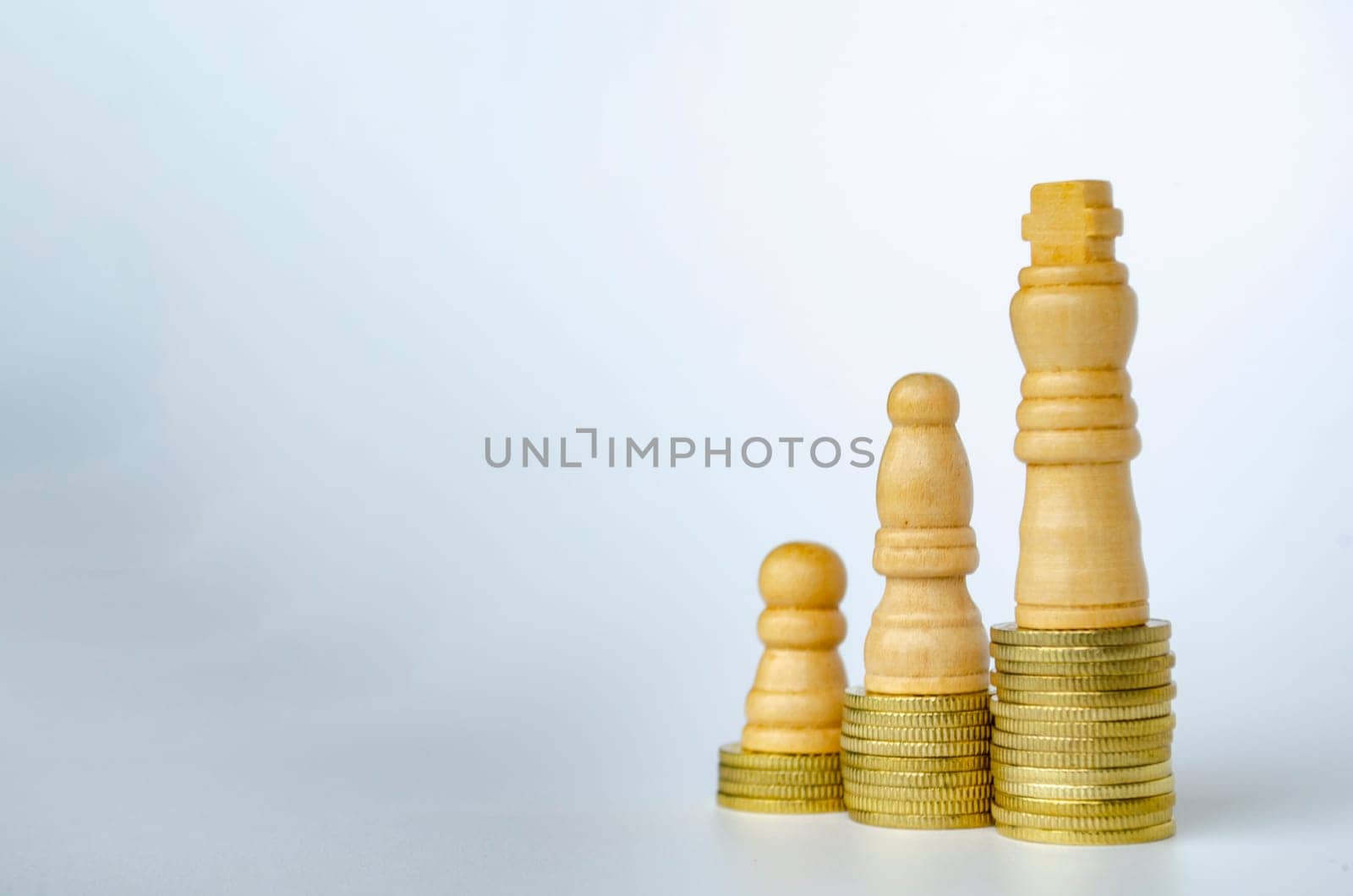 Chess pawns on top of golden stacking coins with customizable space for text or ideas.