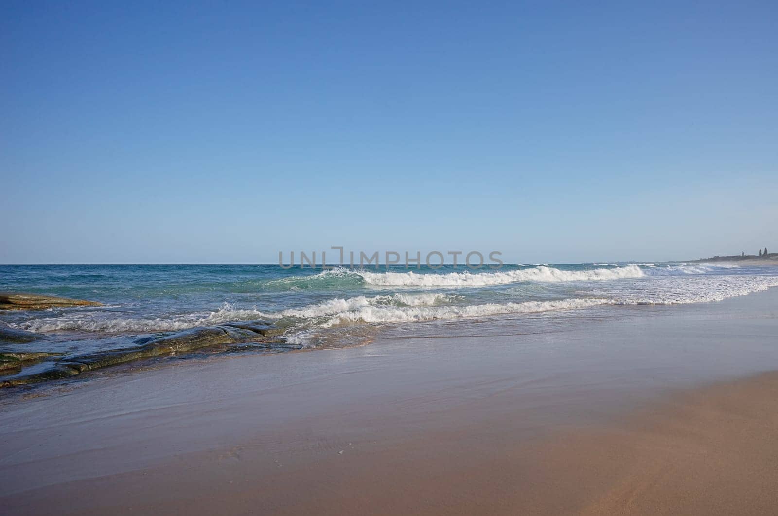 Surf waves breaking along the beach south from Point Cartwright, Buddina, Sunshine Coast, Queensland, Australia, a very popular holiday and tourist area.