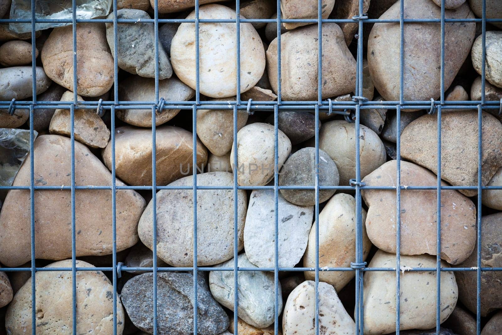 metallic basket net filled by natural stones as a fence