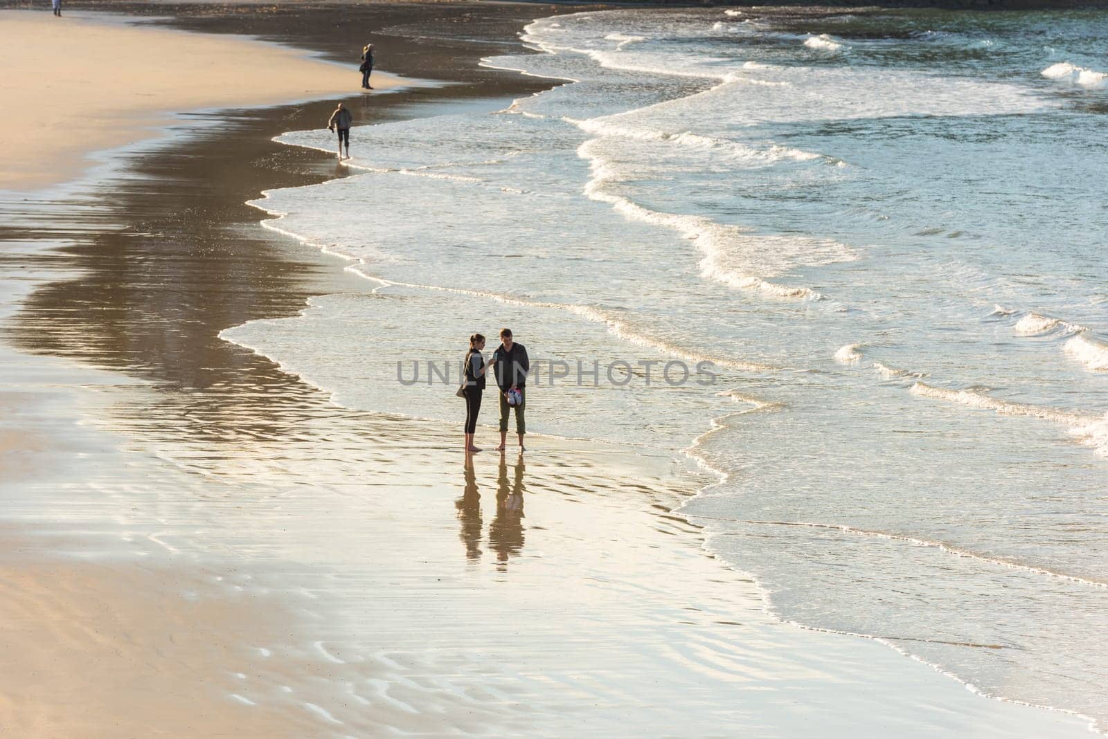 FRANCE, HENDAYE - SEPTEMBER 23: happy romantic couple walking on the atlantic beach. travel vacation on September 23, 2015