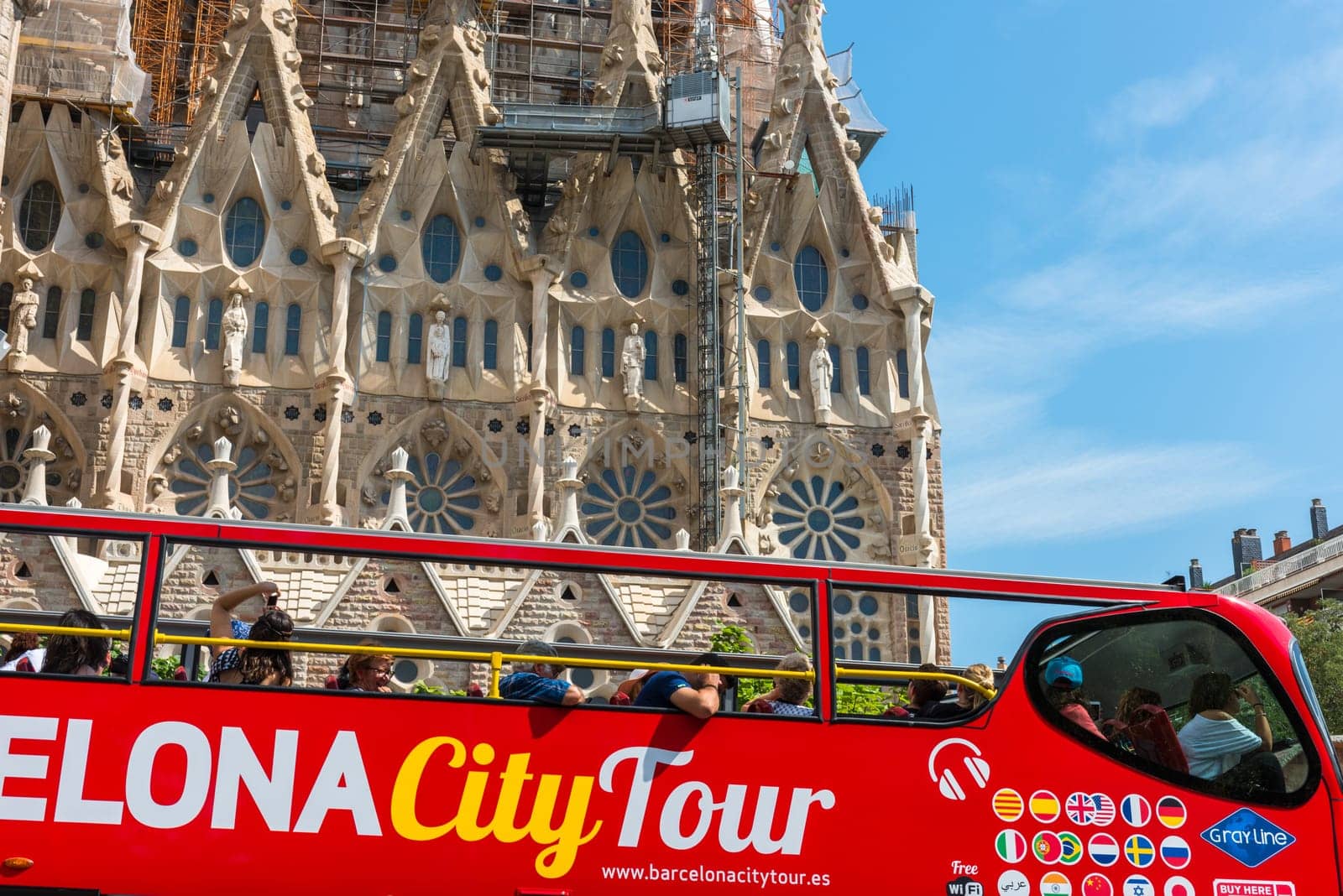 SPAIN, BARCELONA - SEPTEMBER 13: People sitting on a double decker tourist coach in front of The Sagrada Familia Cathedral in Barcelona on September 13, 2015