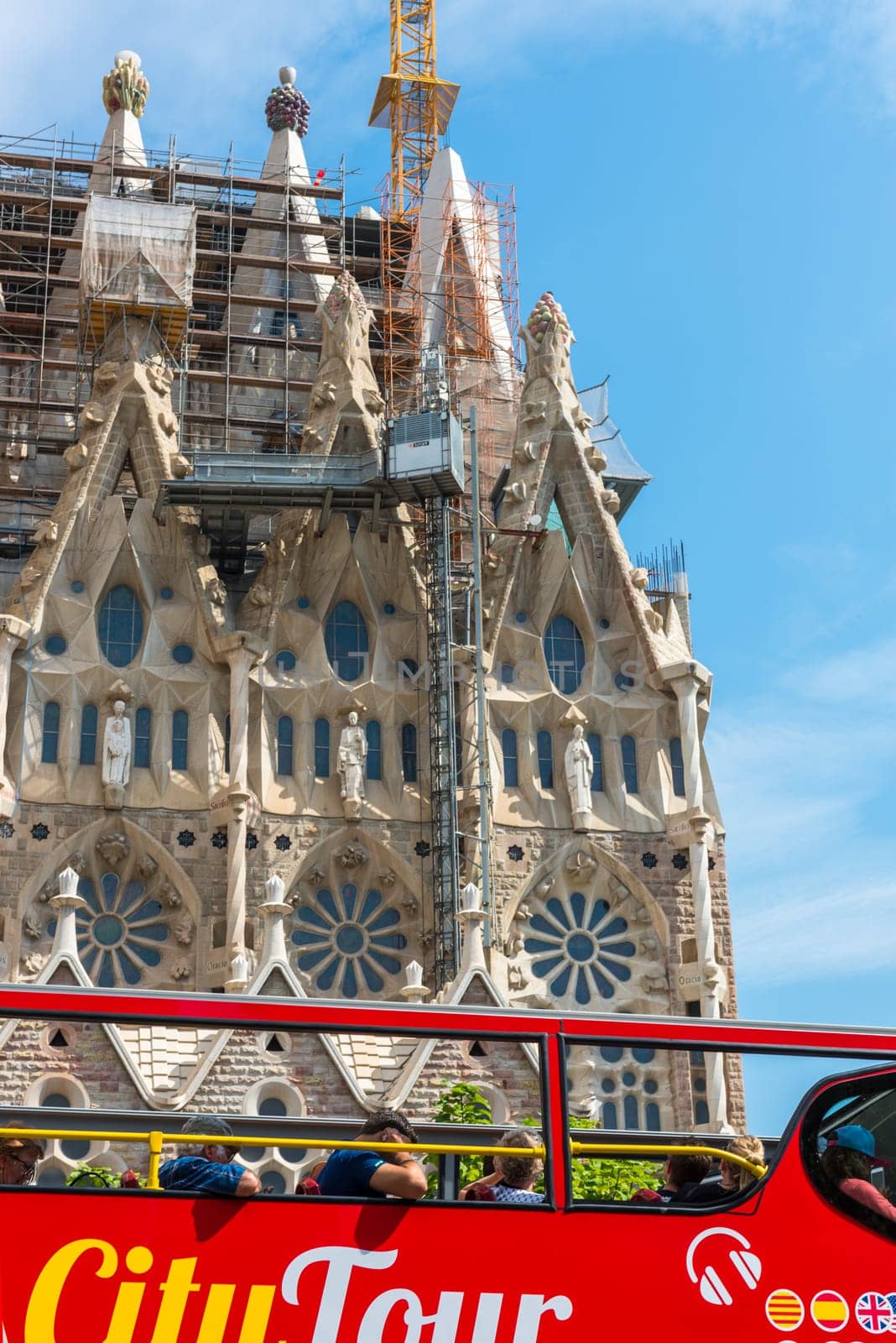 SPAIN, BARCELONA - SEPTEMBER 13: People sitting on a double decker tourist coach in front of The Sagrada Familia Cathedral in Barcelona on September 13, 2015