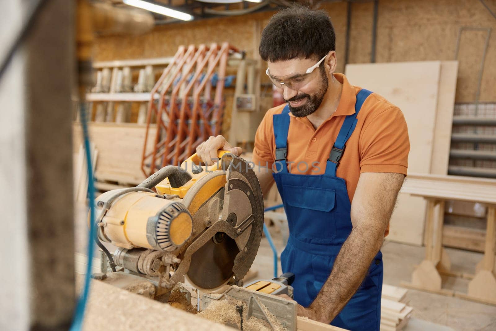 Carpenter working with circular saw enjoying craftsmanship at workshop. Professional equipment for woodwork master for wooden furniture manufacturing