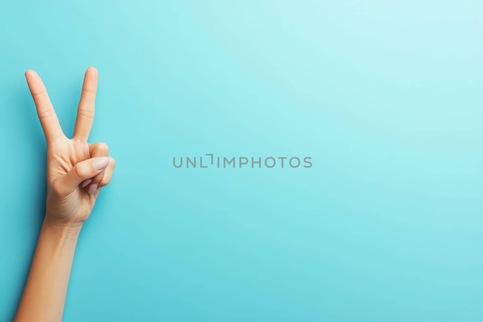 A hand displays a classic peace sign against a solid turquoise background, conveying a message of unity and positivity. The simplicity of the background highlights the gestures significance.