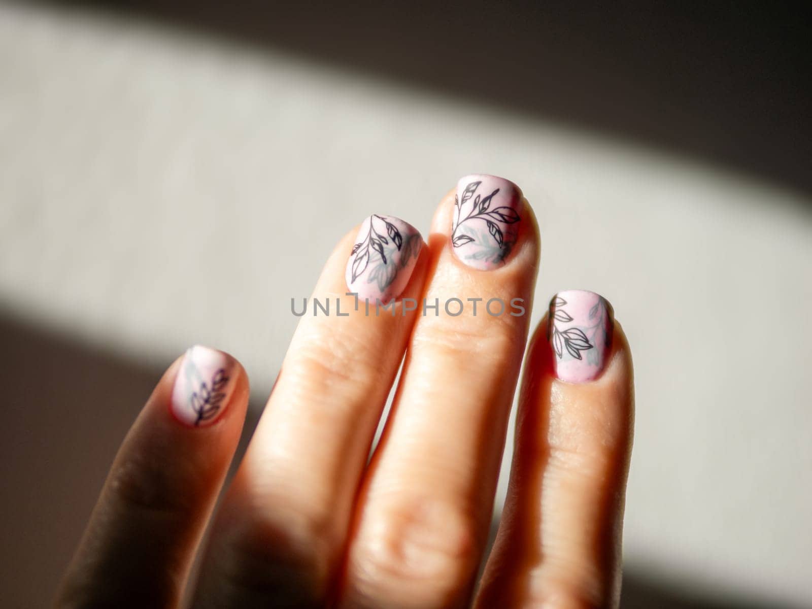 Female Hands With Light Pink Milky Aura Nails Manicure. Woman Fingernails With Pink Nails In Hard Sunlight Background. Floral Botanical Stamping. Aesthetic Visual Of Trendy Manicure With Nail Art.