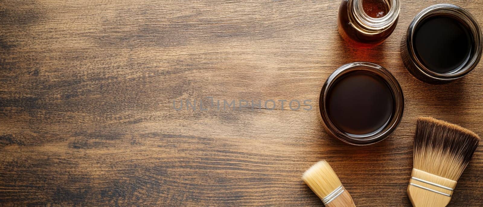 Jars of wood stain with brushes on a textured wooden background, offering ample copy space for text.