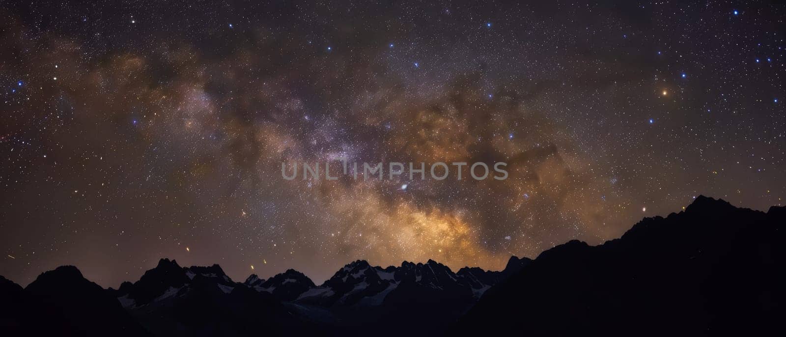 The galactic core of the Milky Way paints a vibrant backdrop above the silhouetted peaks of towering mountains.