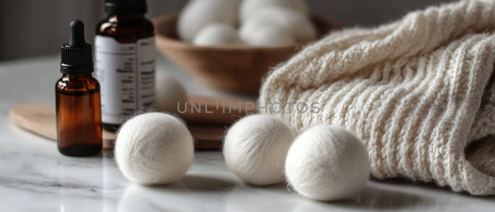 Wool dryer balls with essential oil bottles on a marble surface, promoting eco friendly laundry solutions.