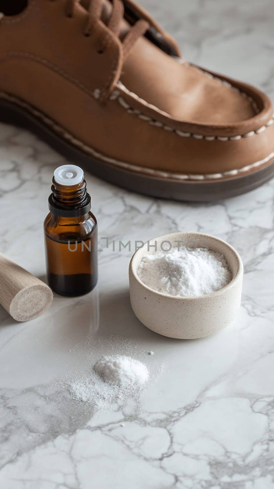 Leather shoe care supplies with essential oil bottle and cleaning powder on marble surface, sustainable footwear maintenance concept.