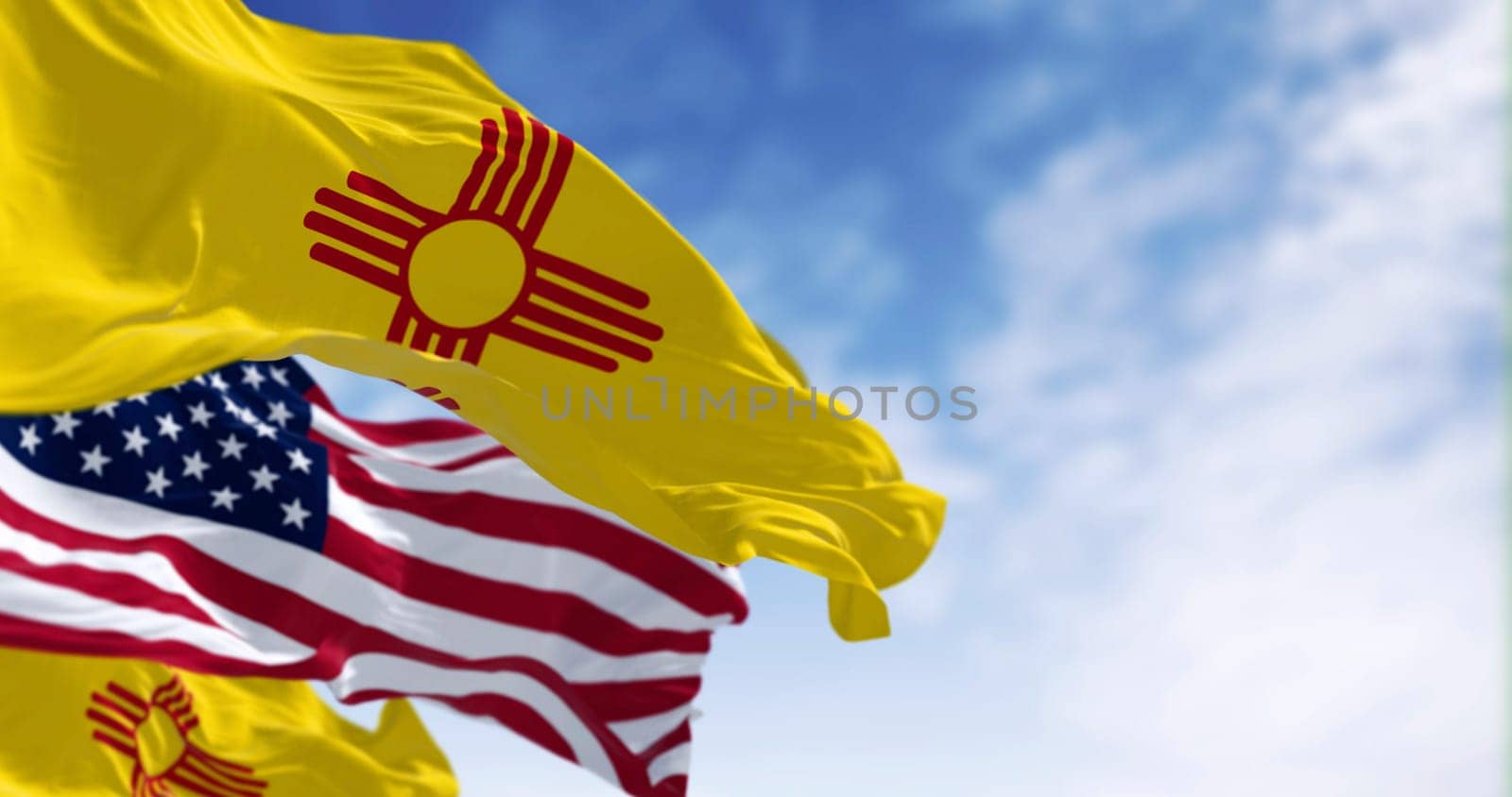 Close-up view of the New Mexico and United States flags waving in the wind on a clear day . 3d illustration render. Selective focus