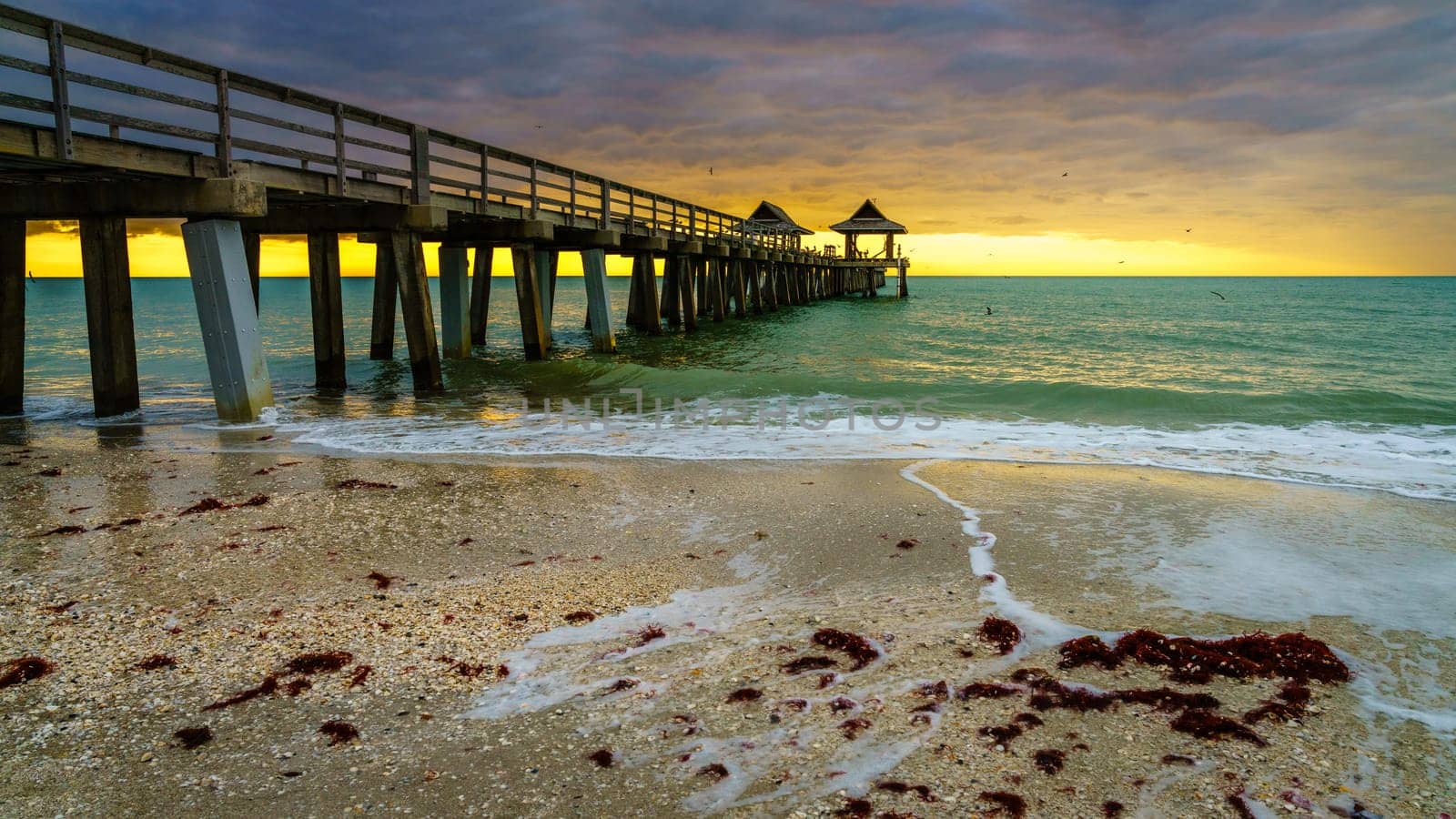Pier and the beach in Naples, Florida, at sunset
