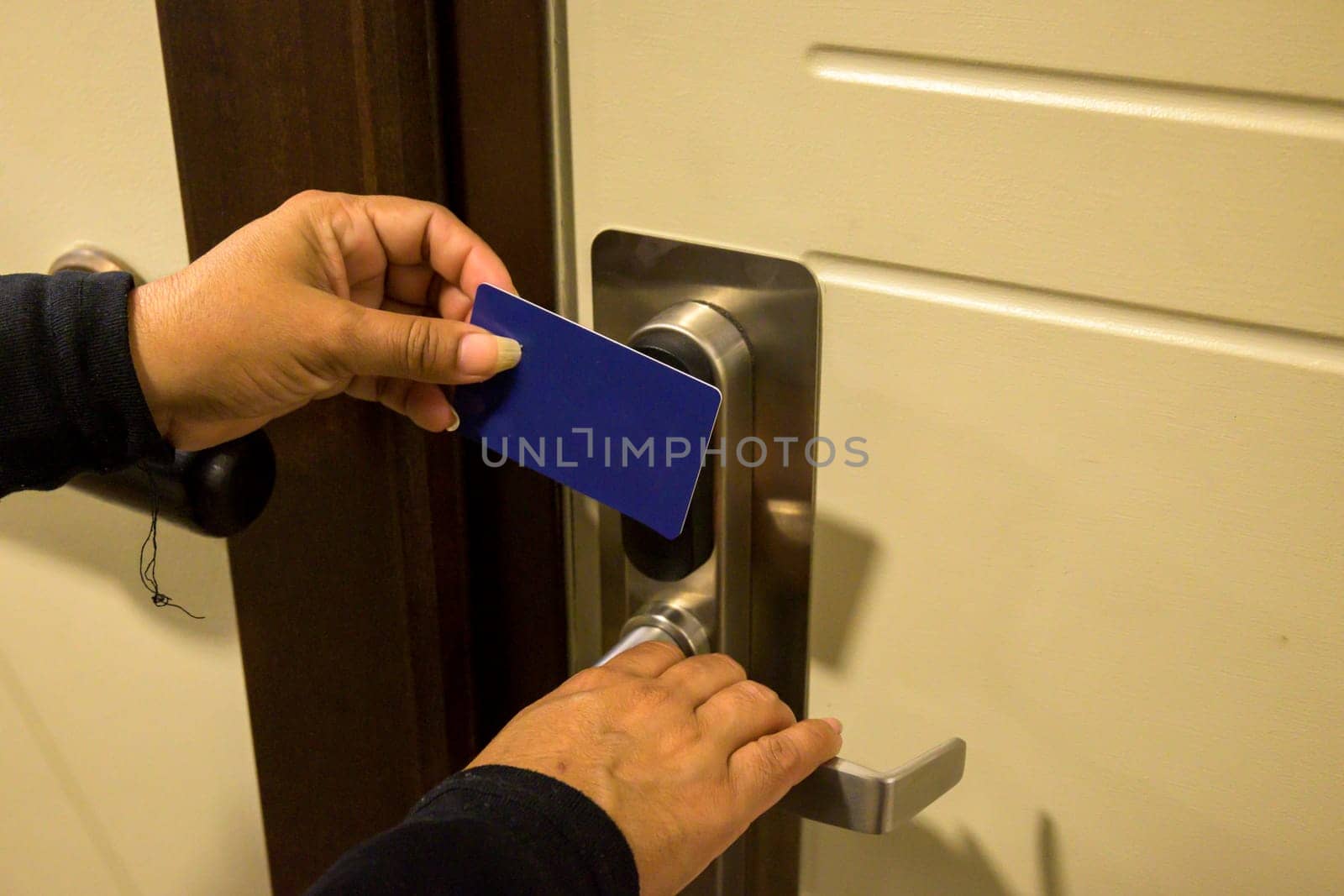 Hands holding a keycard near a door lock for entry, key electronic lock, hotel room, holidays in mallorca, spain