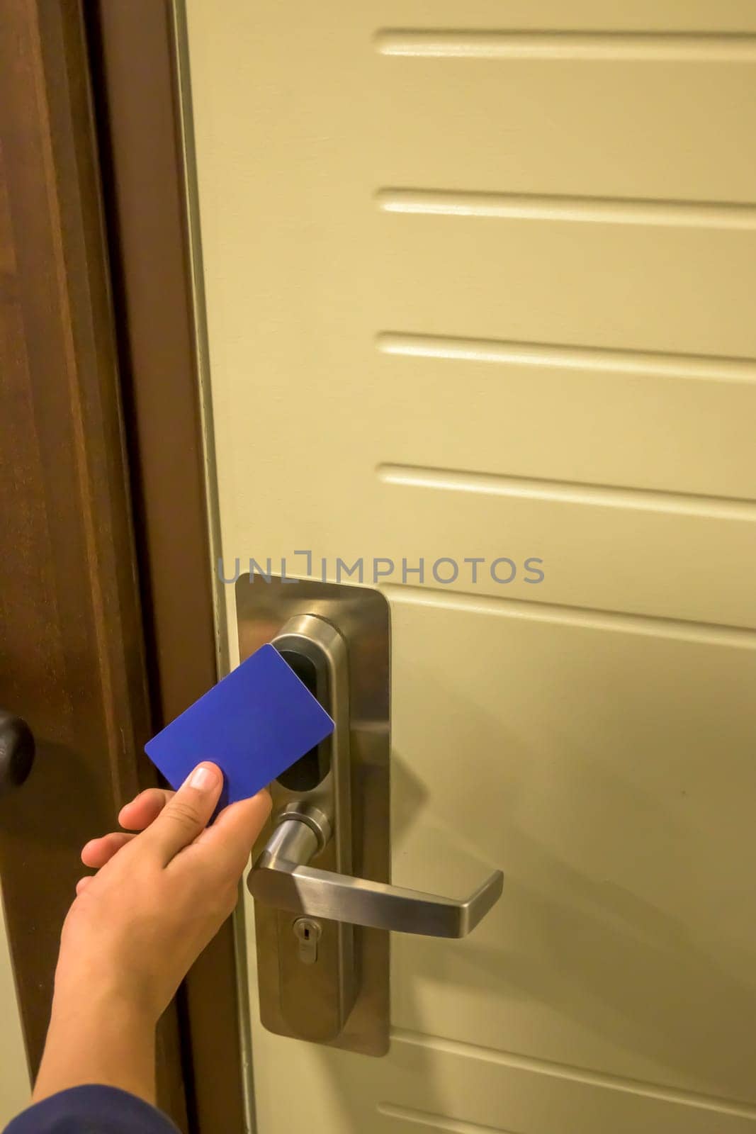 Close-up of a hand using a blue card key on a hotel door lock, key electronic lock, hotel room, holidays in mallorca, spain.
