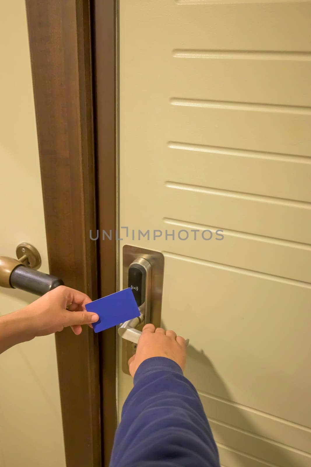 A hand inserting a blue card key into a modern hotel door lock, key electronic lock, hotel room, holidays in mallorca, spain