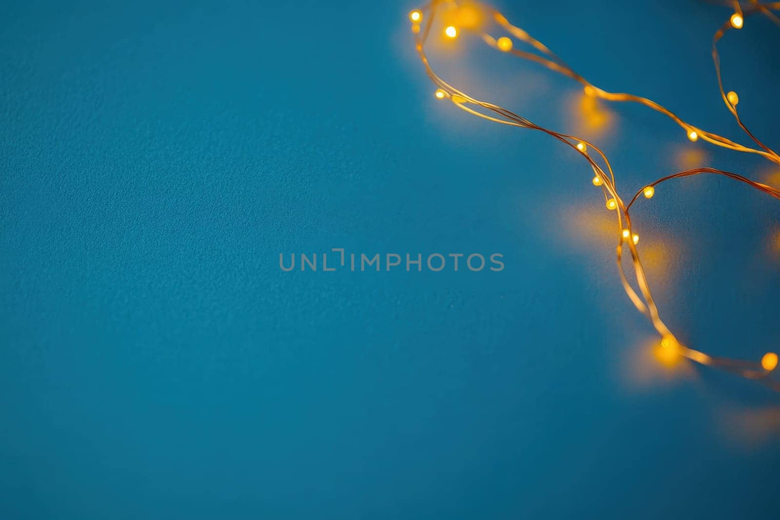 A string of sparkling fairy lights glimmers against a clean solid background, radiating warmth and charm. The soft glow enhances the serene ambiance, inviting a sense of wonder.