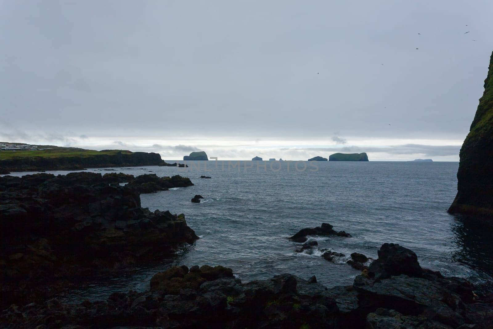 Vestmannaeyjar island beach view with Surtsey island in background. Iceland landscape