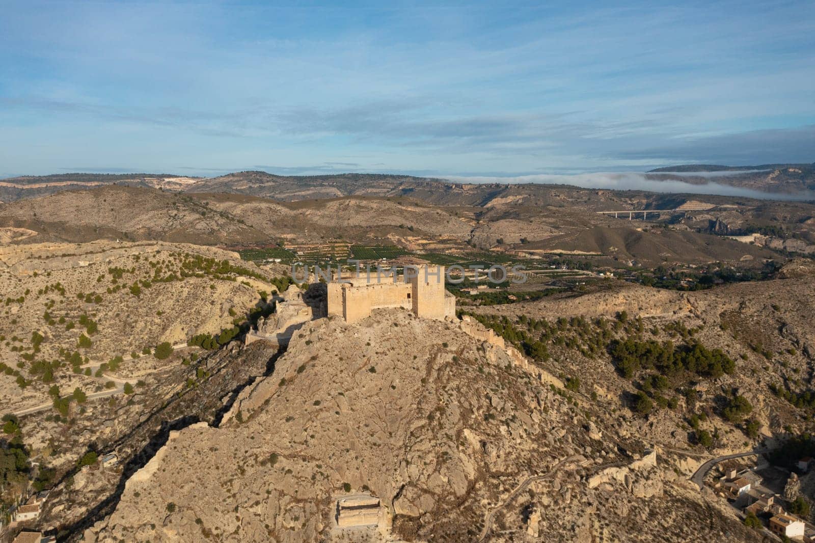 Aerial view of the impressive medieval castle of Mula, Region of Murcia, Spain, on a steep, rocky hill